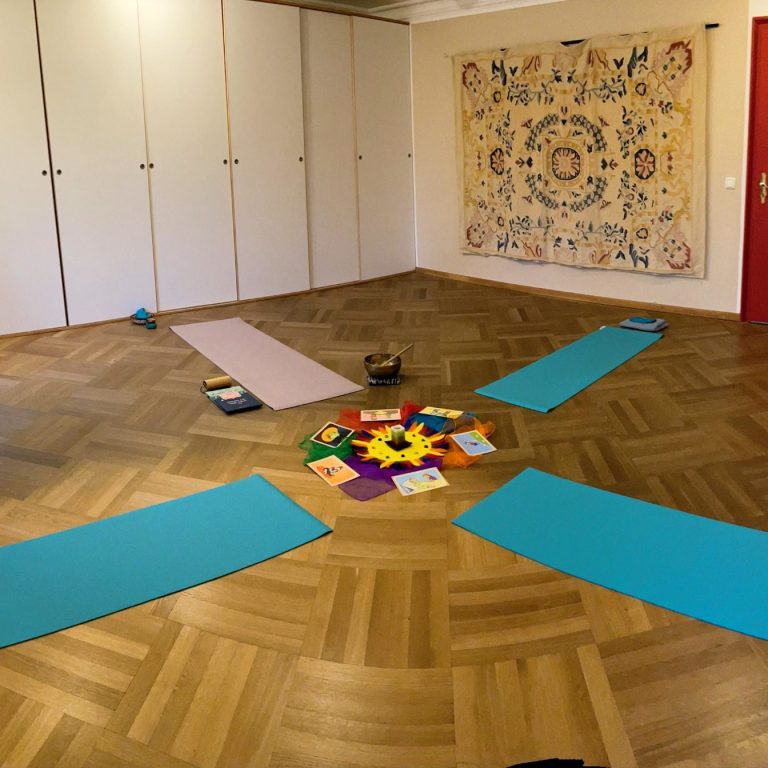 Boden mit Yoga-Matten und bunten Materialien in einem lichtdurchfluteten Raum.