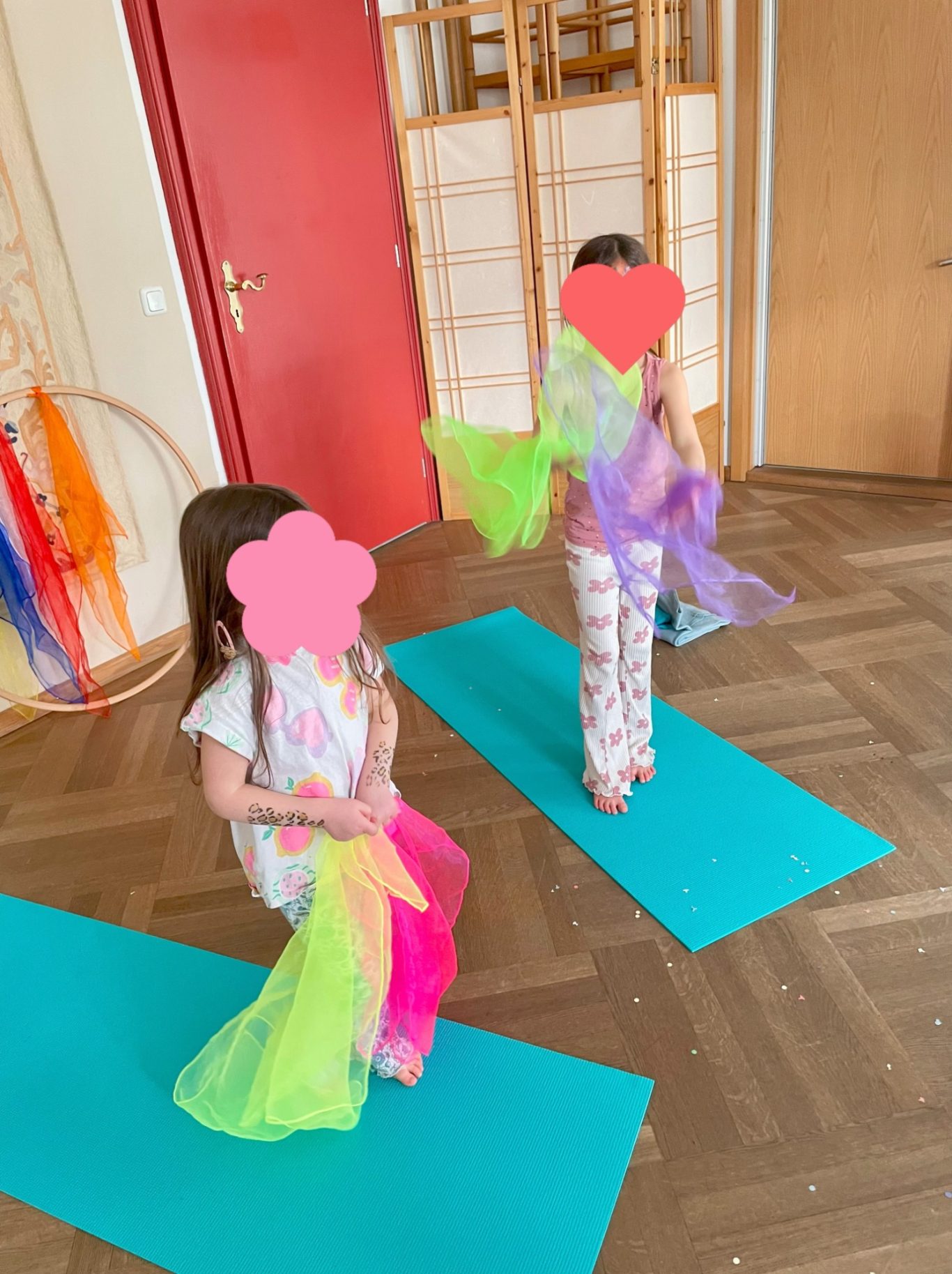 Zirkusartisten Zwei Kinder stehen auf einer Matte und halten bunte Tücher in den Händen.