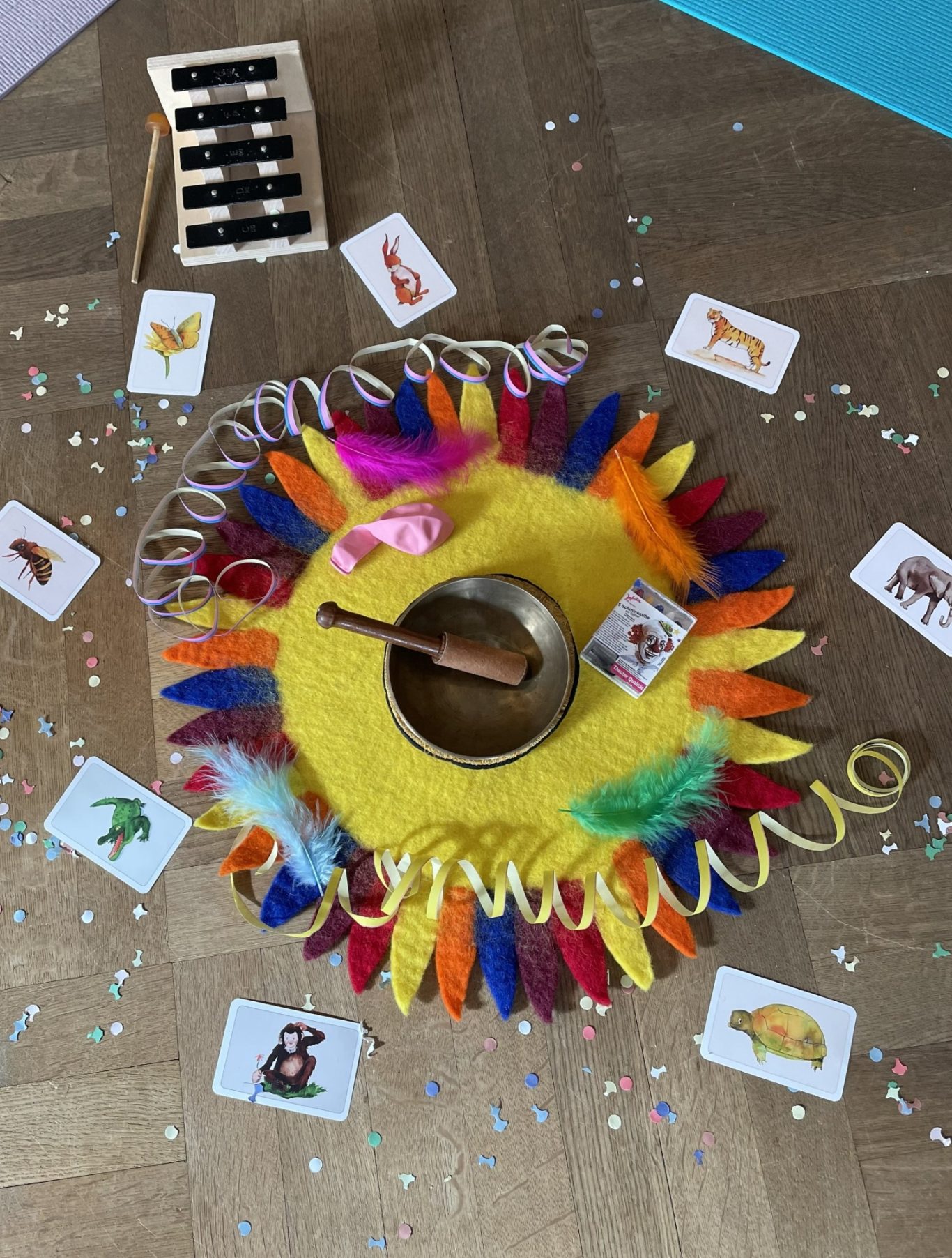 Fasching mit den jungen Kindern Buntes Kinder-Spielzeug-Set mit Tieren, einer Klangschale und bunten Dekorationen.